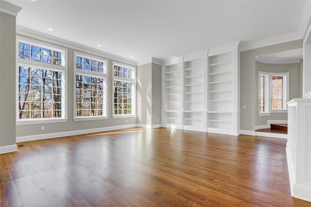 interior space featuring crown molding, plenty of natural light, dark hardwood / wood-style floors, and built in shelves