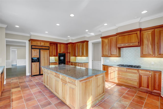 kitchen with dark stone countertops, crown molding, light tile patterned flooring, and a kitchen island