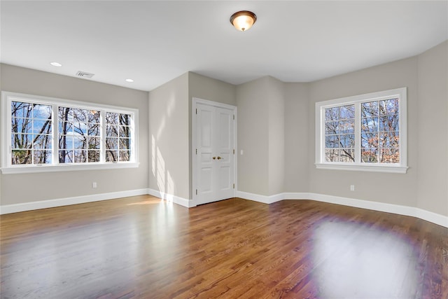 unfurnished room with hardwood / wood-style flooring and a healthy amount of sunlight