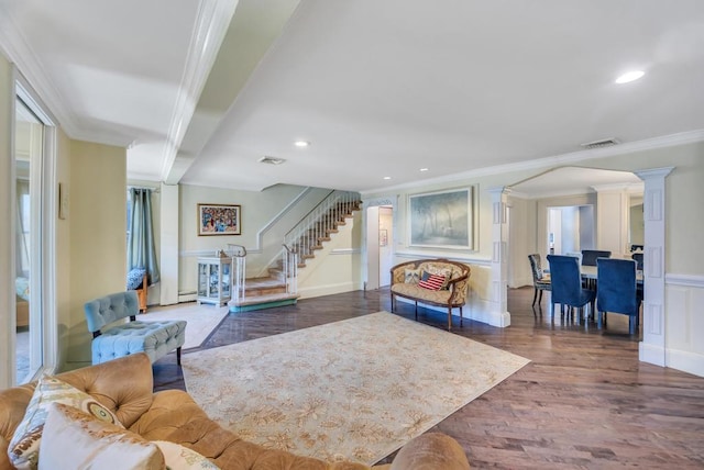 living room featuring ornate columns, ornamental molding, and dark wood-type flooring