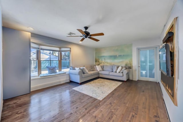 unfurnished living room featuring ceiling fan and dark hardwood / wood-style floors