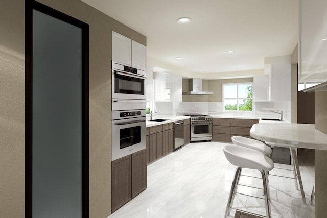 kitchen featuring wall chimney exhaust hood, sink, white cabinetry, appliances with stainless steel finishes, and backsplash