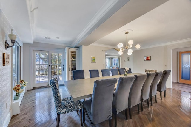 dining room with ornamental molding, plenty of natural light, an inviting chandelier, and dark hardwood / wood-style flooring