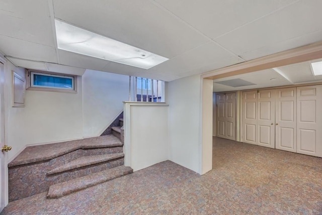 basement featuring light colored carpet and a drop ceiling