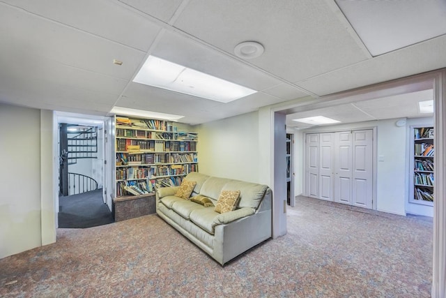 living area featuring a drop ceiling and carpet floors