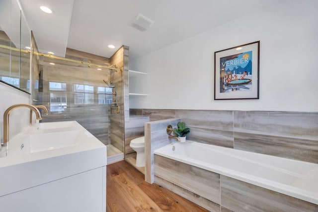 full bathroom featuring tile walls, vanity, wood-type flooring, independent shower and bath, and toilet