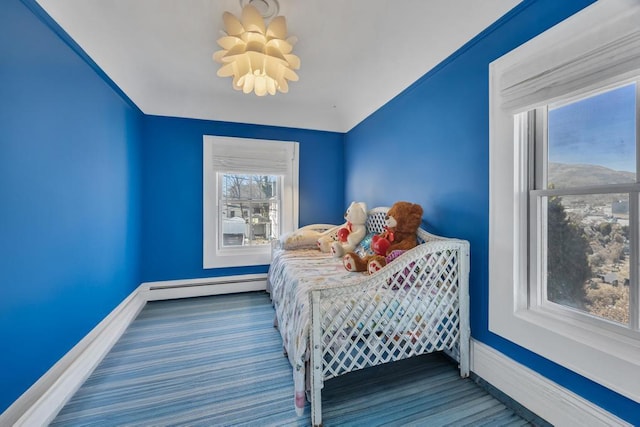 bedroom featuring hardwood / wood-style floors and a baseboard heating unit