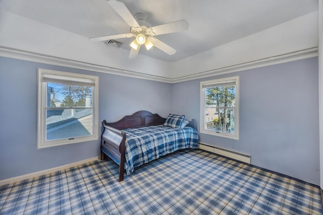 bedroom with multiple windows, a baseboard heating unit, and ceiling fan