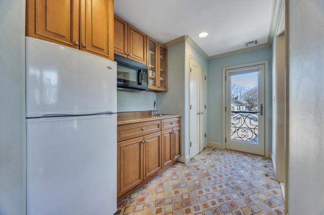 kitchen featuring sink, crown molding, and white refrigerator