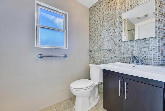 bathroom featuring tile walls, vanity, tile patterned floors, and toilet