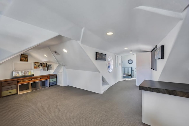 interior space with vaulted ceiling and dark carpet