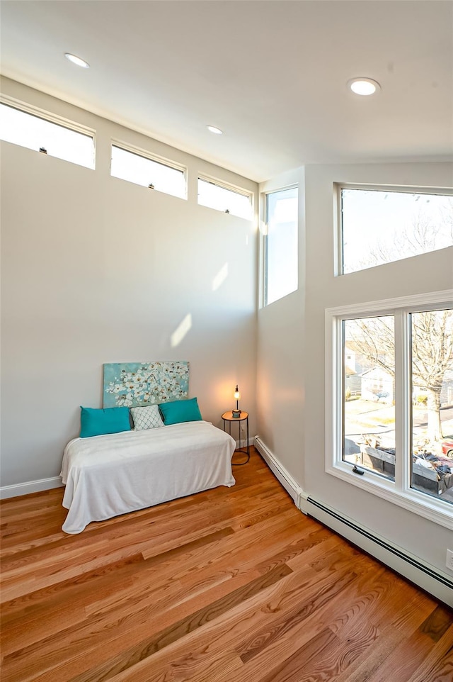 bedroom featuring baseboard heating and light wood-type flooring