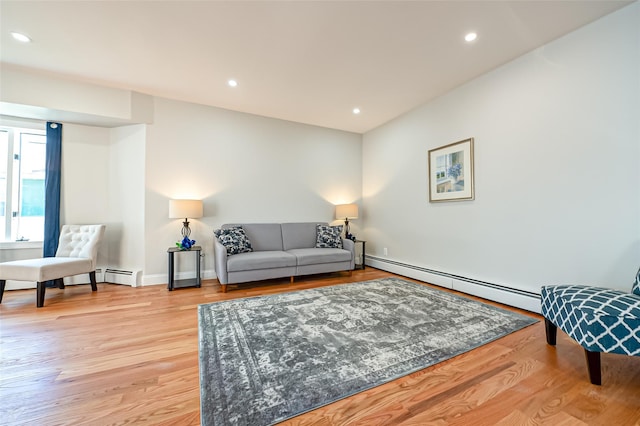 living room featuring a baseboard heating unit and light hardwood / wood-style flooring