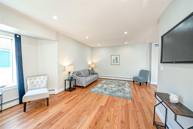 living room with light hardwood / wood-style floors and baseboard heating