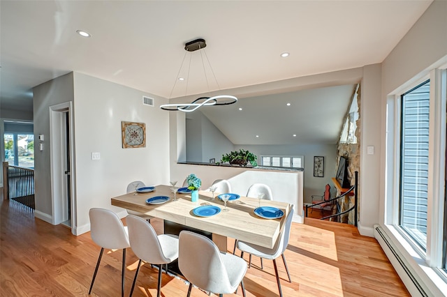 dining area featuring baseboard heating and light hardwood / wood-style flooring