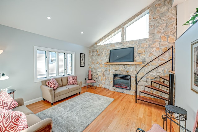 living room featuring lofted ceiling, a fireplace, and hardwood / wood-style flooring