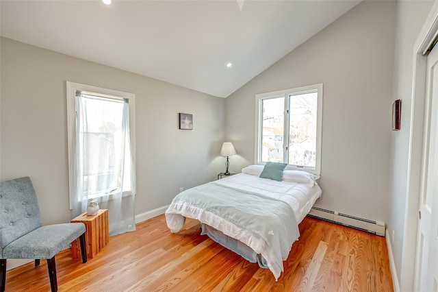 bedroom featuring light hardwood / wood-style floors, multiple windows, vaulted ceiling, and a baseboard radiator