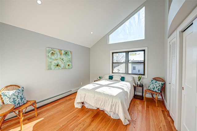 bedroom with high vaulted ceiling, light hardwood / wood-style floors, and a closet