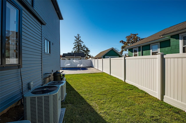 view of yard with central AC and a patio