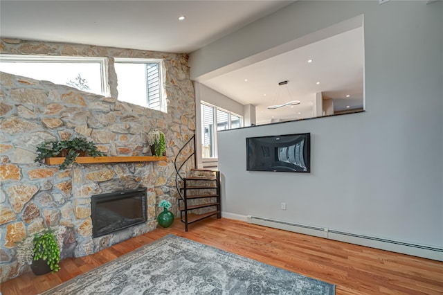 2726 Clarendon Ave, Bellmore, NY 11710 - unfurnished living room featuring a fireplace, a baseboard heating unit, and wood finished floors