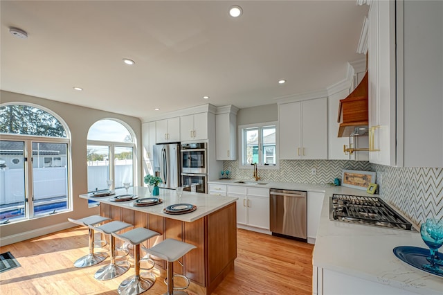 2726 Clarendon Ave, Bellmore, NY 11710 - kitchen with appliances with stainless steel finishes, light wood-style floors, backsplash, a kitchen bar, and recessed lighting