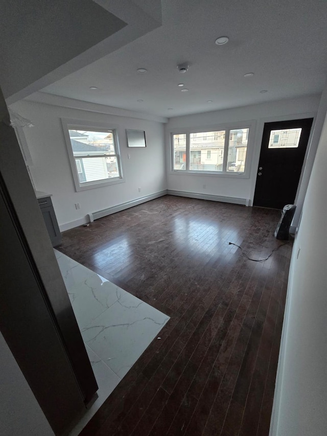 interior space with dark hardwood / wood-style floors and baseboard heating