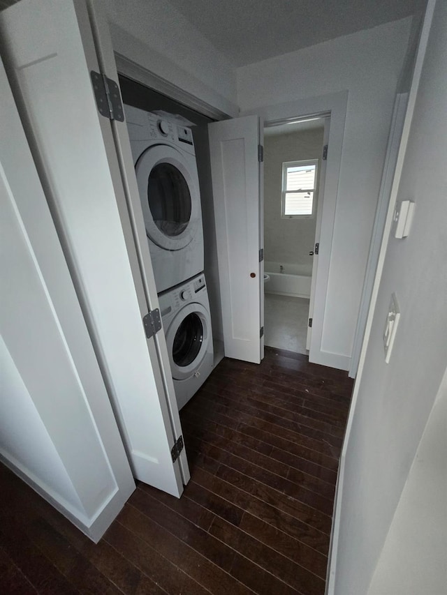 clothes washing area with dark hardwood / wood-style flooring and stacked washing maching and dryer