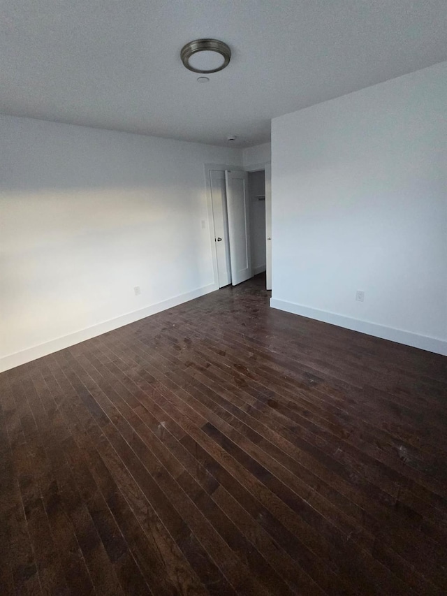 empty room with dark wood-type flooring