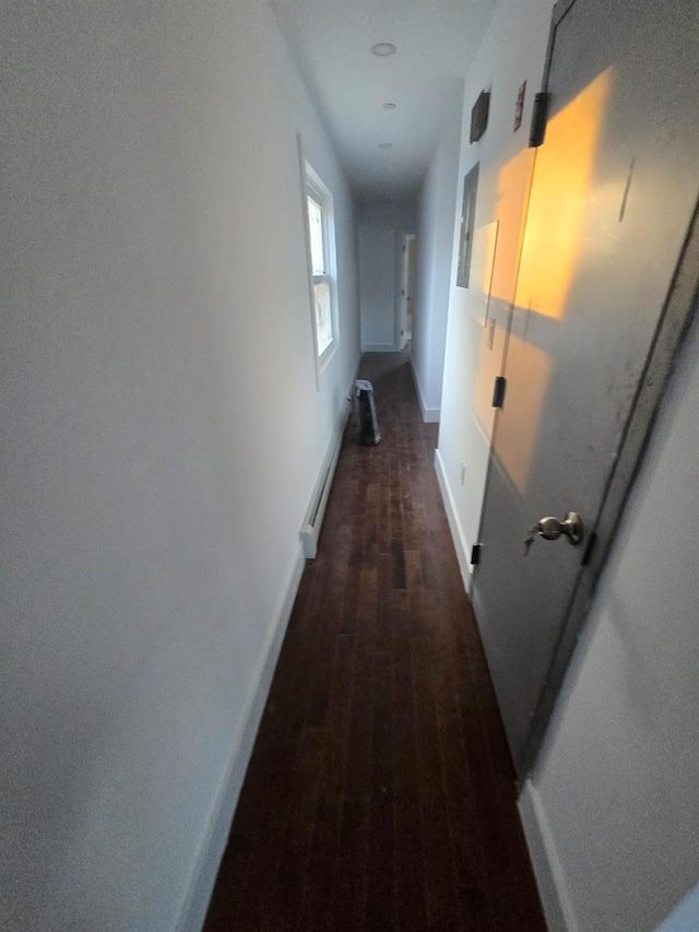 hallway featuring dark hardwood / wood-style flooring and baseboard heating