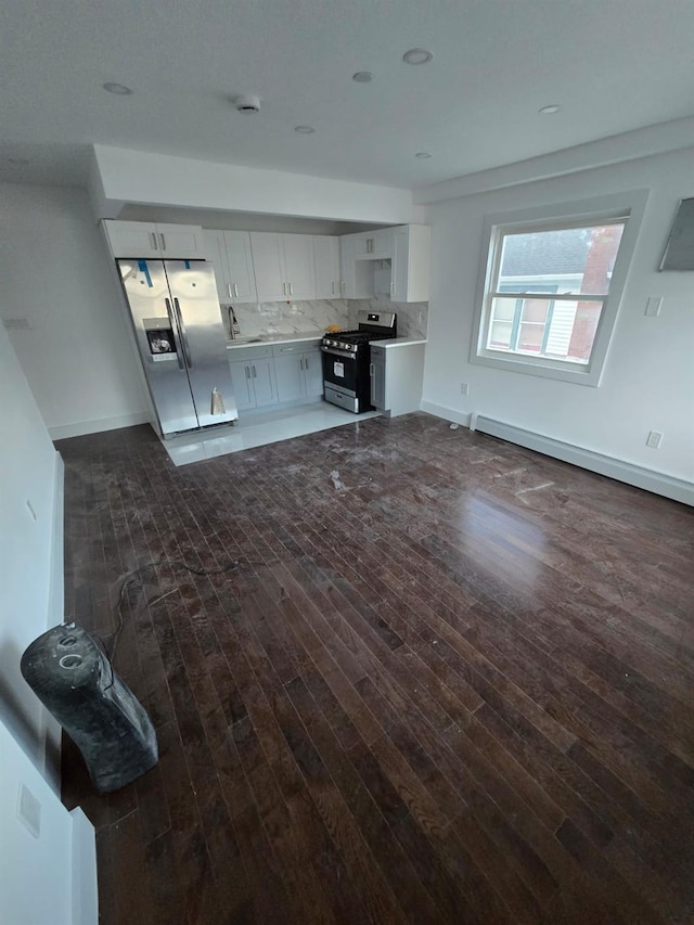 kitchen with sink, dark wood-type flooring, decorative backsplash, white cabinets, and appliances with stainless steel finishes