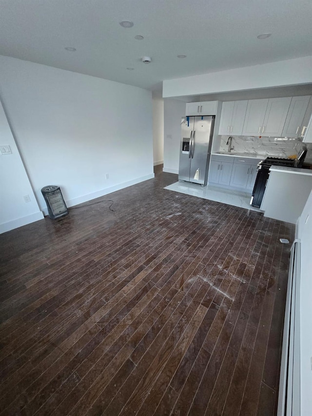 unfurnished living room with dark hardwood / wood-style floors and sink