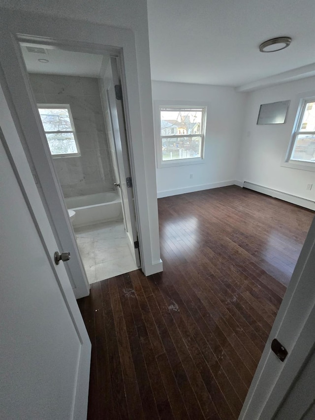 corridor featuring dark hardwood / wood-style flooring and baseboard heating