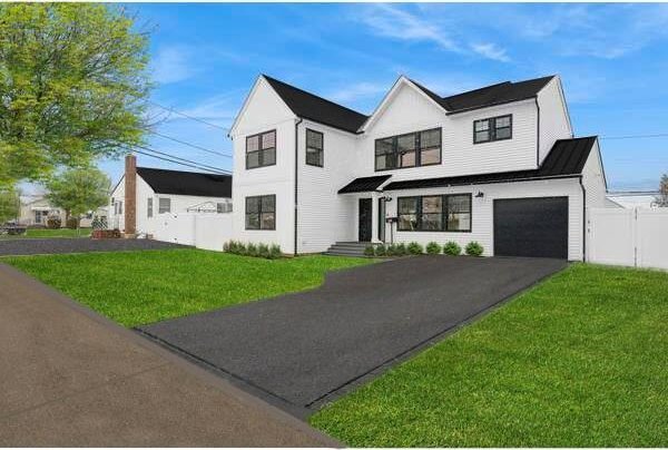 modern inspired farmhouse with a garage and a front lawn