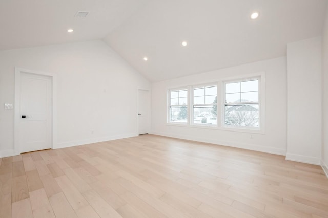 spare room featuring light hardwood / wood-style floors and lofted ceiling