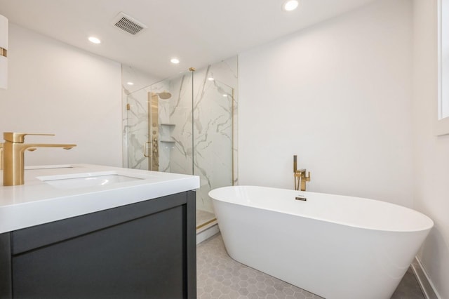 bathroom featuring tile patterned floors, vanity, and shower with separate bathtub