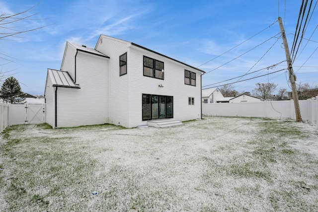 rear view of property featuring a lawn