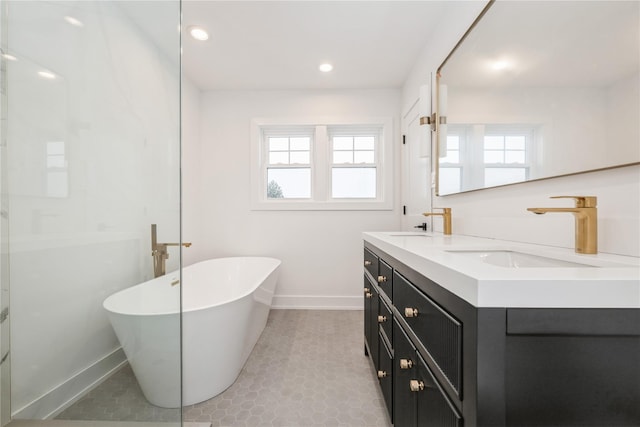 bathroom featuring tile patterned flooring, a bath, vanity, and plenty of natural light