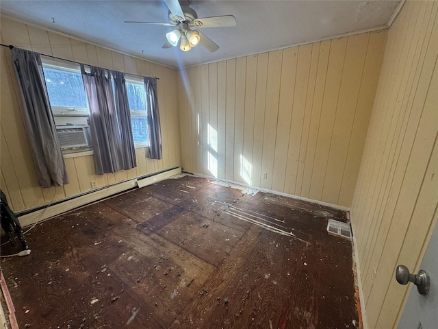 empty room with ceiling fan, wood walls, baseboard heating, and cooling unit