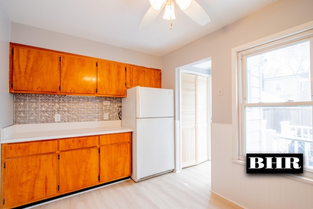 kitchen featuring white refrigerator, tasteful backsplash, ceiling fan, and light hardwood / wood-style floors