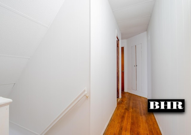 hallway with wood-type flooring and wooden walls