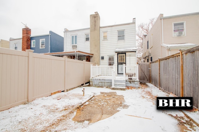 snow covered property with cooling unit