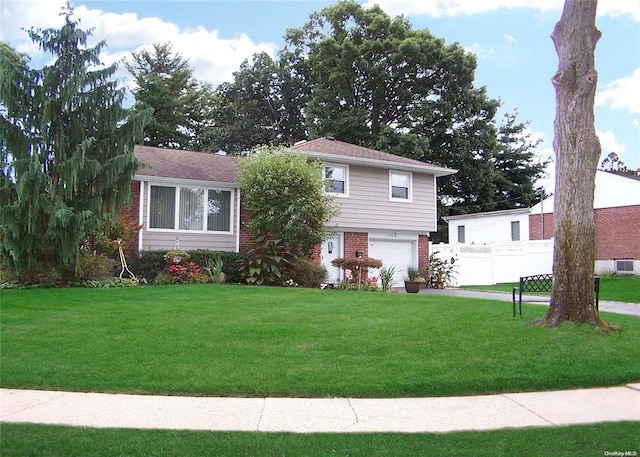 tri-level home with a garage and a front yard