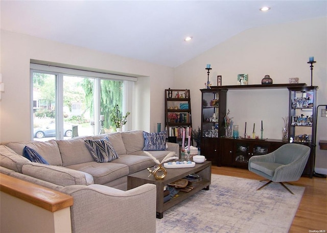 living room featuring light wood-type flooring and lofted ceiling