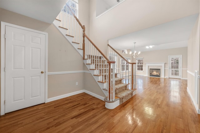 stairs with a chandelier and hardwood / wood-style floors