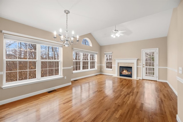 unfurnished living room with vaulted ceiling, light hardwood / wood-style flooring, and a healthy amount of sunlight