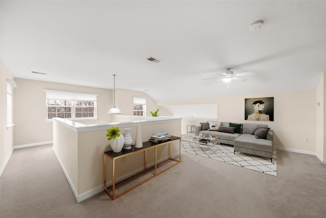 living room with lofted ceiling, ceiling fan, and light colored carpet