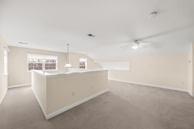 carpeted spare room with ceiling fan and vaulted ceiling