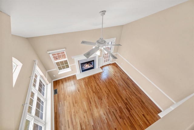 unfurnished living room with a high ceiling, hardwood / wood-style flooring, and a wealth of natural light