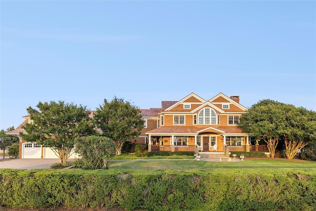 view of front of house with covered porch and a front lawn