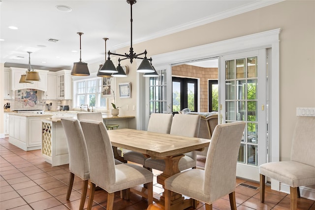 dining room featuring crown molding, french doors, and light tile patterned floors